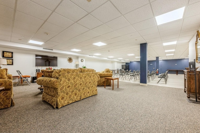 living room with a drop ceiling and carpet