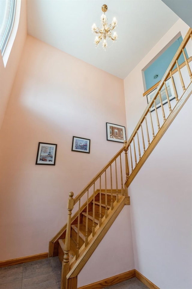 stairs with a chandelier and baseboards