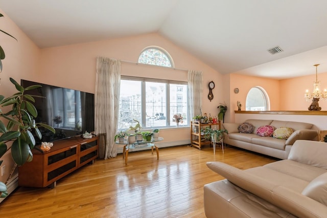 living area featuring a chandelier, a baseboard heating unit, wood finished floors, visible vents, and vaulted ceiling