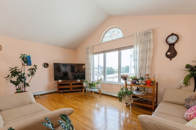 living area featuring lofted ceiling, baseboard heating, wood finished floors, and a healthy amount of sunlight