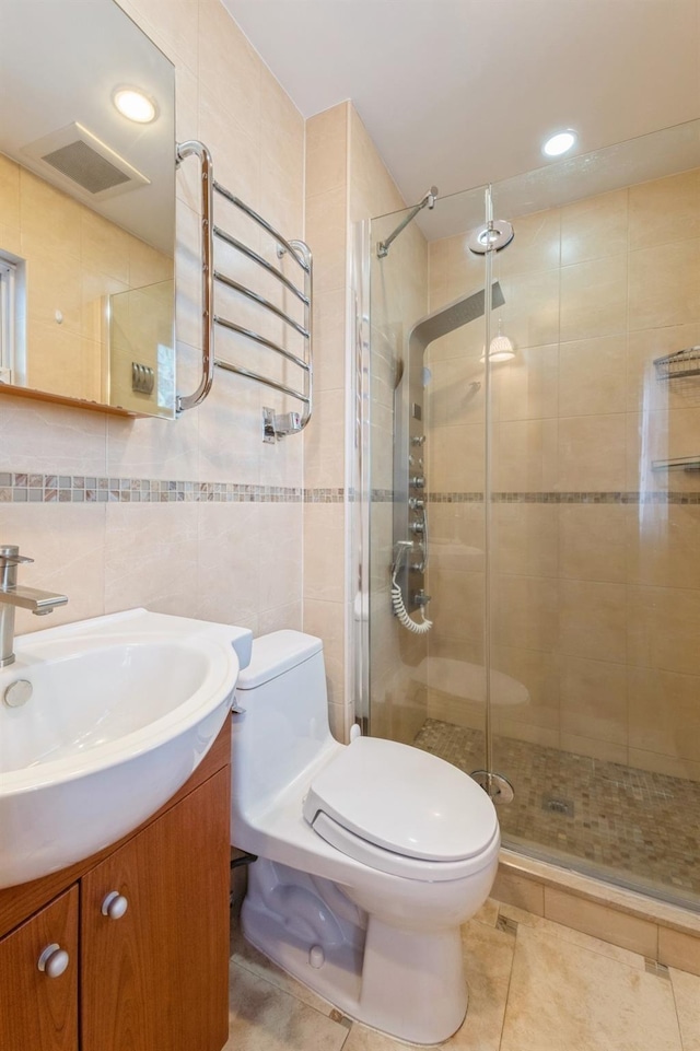 full bathroom featuring tile walls, a shower stall, toilet, and vanity