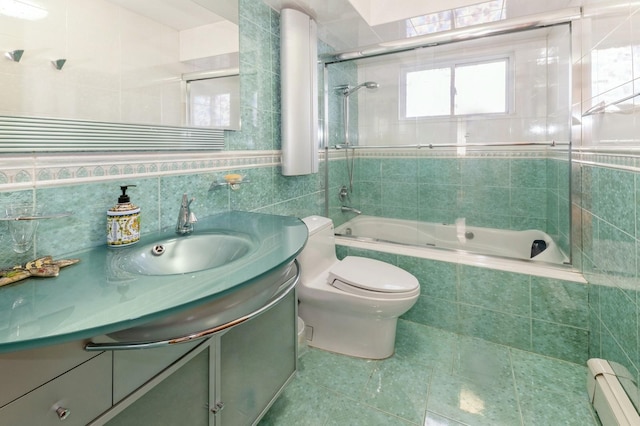 bathroom featuring toilet, tiled shower / bath combo, vanity, a baseboard heating unit, and tile walls