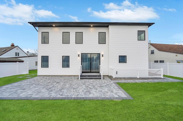 rear view of house featuring a patio, a lawn, and fence private yard