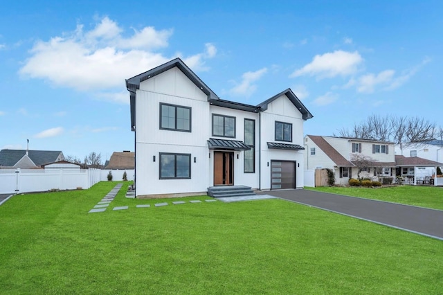 modern farmhouse style home featuring a standing seam roof, a front lawn, fence, and metal roof