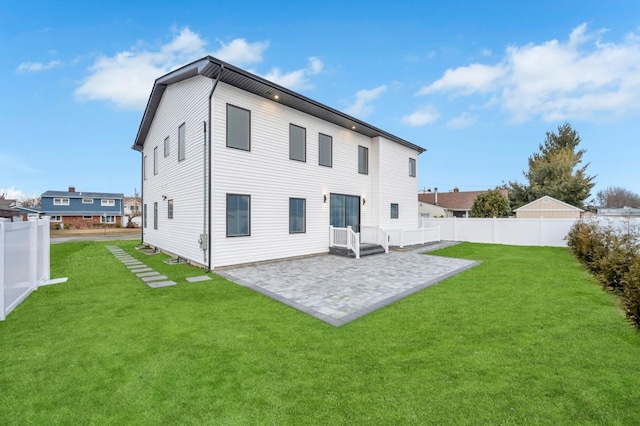 rear view of house featuring a yard, a fenced backyard, and a patio area