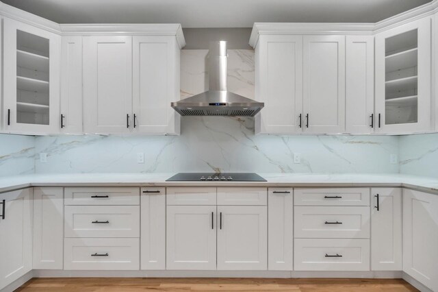 20 Baker Ln, Levittown, NY 11756 - kitchen with black electric cooktop, white cabinetry, light countertops, and wall chimney range hood