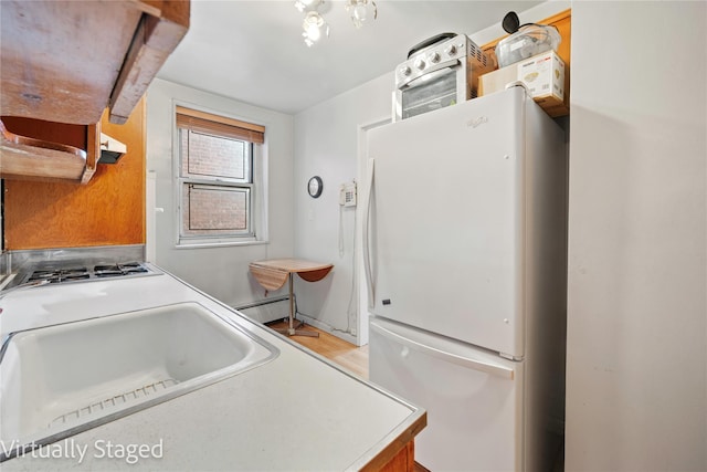 bathroom featuring a baseboard heating unit and a sink