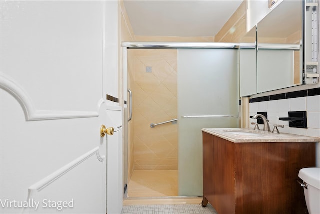 bathroom featuring vanity, backsplash, a shower stall, and toilet