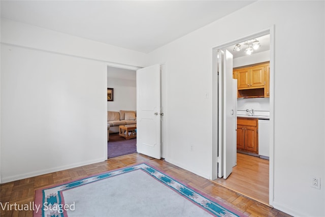 unfurnished bedroom featuring a sink and baseboards