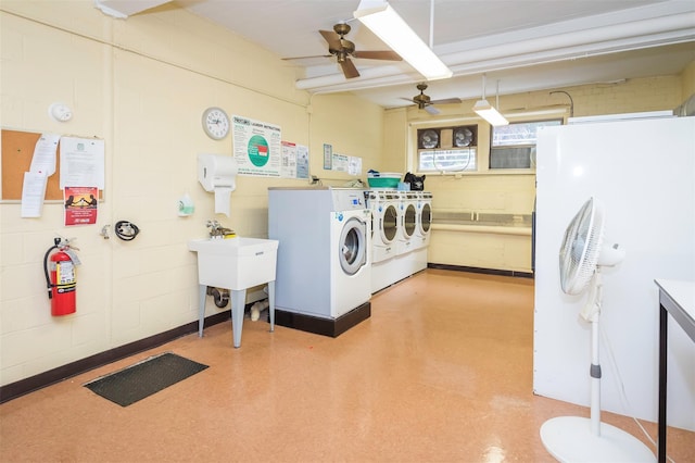 shared laundry area featuring washer and dryer and concrete block wall