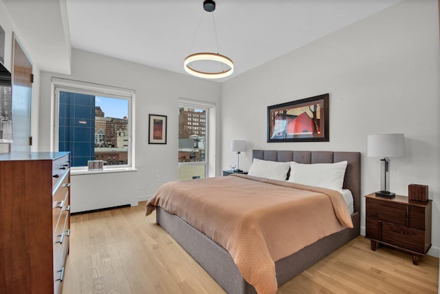 bedroom with light wood-type flooring and baseboards