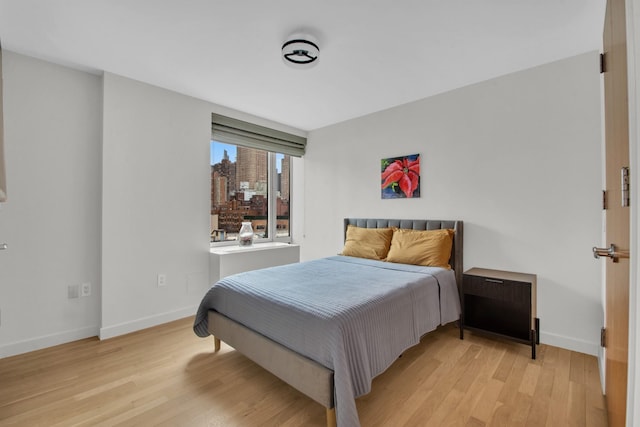 bedroom with baseboards and wood finished floors