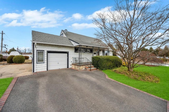 view of front of property featuring aphalt driveway, a front yard, a garage, and roof with shingles