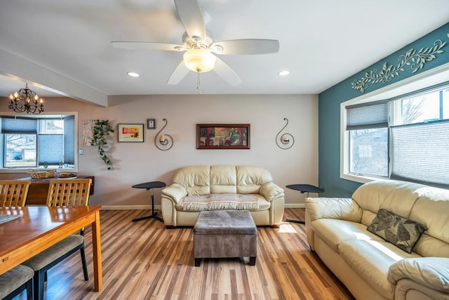 living area with recessed lighting, baseboards, light wood-style flooring, and ceiling fan with notable chandelier