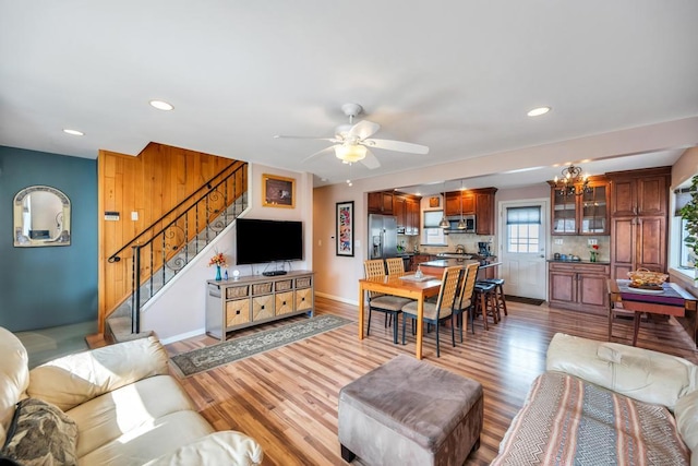 living room featuring baseboards, stairs, recessed lighting, light wood-style floors, and a ceiling fan