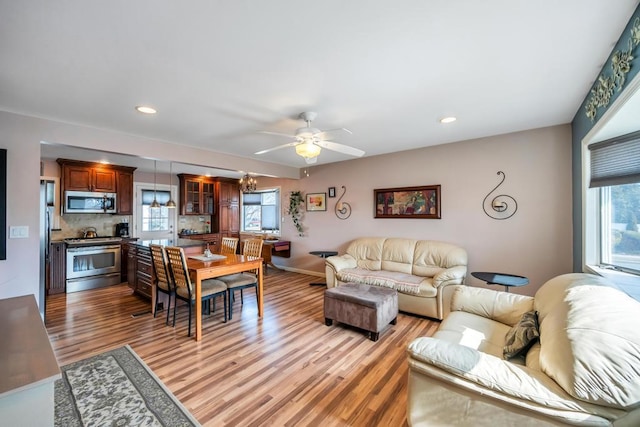 living area with recessed lighting, light wood-style flooring, baseboards, and ceiling fan