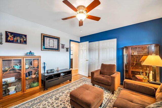 living room featuring a ceiling fan and light wood-type flooring