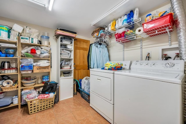 laundry room with light tile patterned flooring, laundry area, and washer and clothes dryer