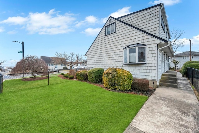 view of home's exterior with a lawn and fence