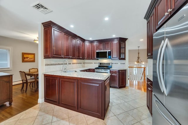 kitchen with visible vents, a sink, tasteful backsplash, stainless steel appliances, and light tile patterned flooring