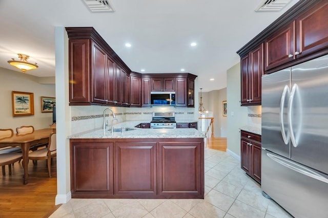 kitchen with visible vents, backsplash, dark brown cabinets, appliances with stainless steel finishes, and a sink