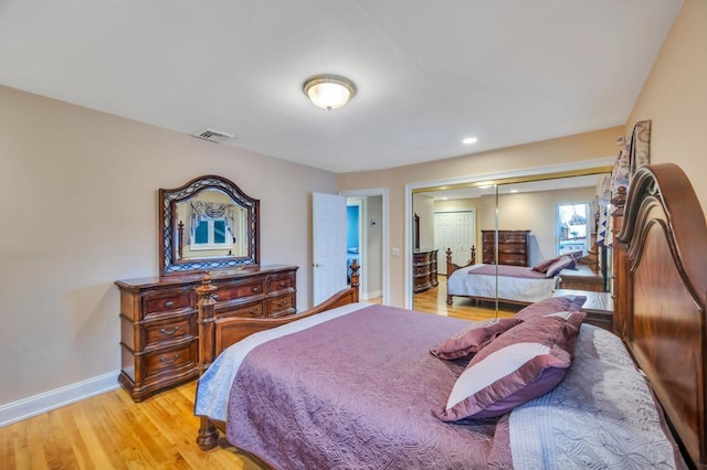 bedroom with visible vents, baseboards, a closet, and light wood-style flooring