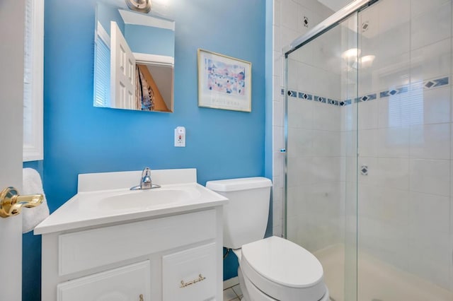 bathroom with toilet, a stall shower, and vanity