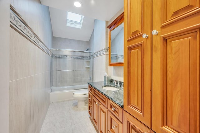 full bathroom featuring vanity, a skylight, tile patterned flooring, toilet, and shower / bathtub combination