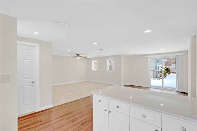 kitchen with recessed lighting, light wood-type flooring, open floor plan, and white cabinetry