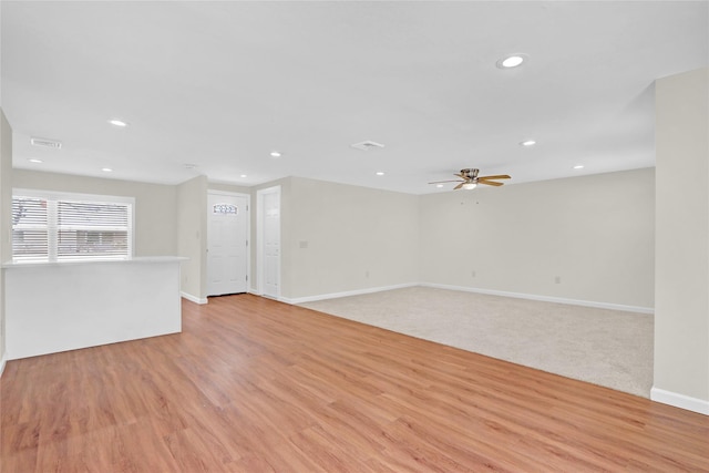 unfurnished living room featuring a ceiling fan, visible vents, baseboards, recessed lighting, and light wood-style floors