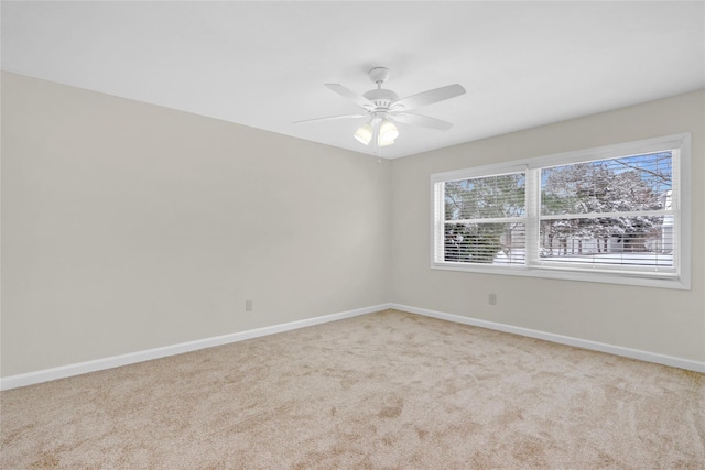 carpeted spare room with baseboards and ceiling fan