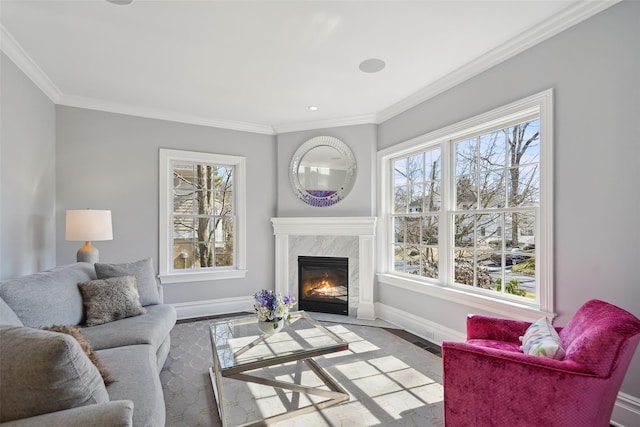 living area with a high end fireplace, crown molding, and baseboards