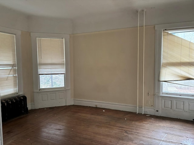 unfurnished room with hardwood / wood-style flooring, plenty of natural light, and baseboards