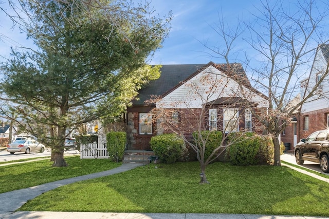 view of front facade featuring brick siding and a front yard