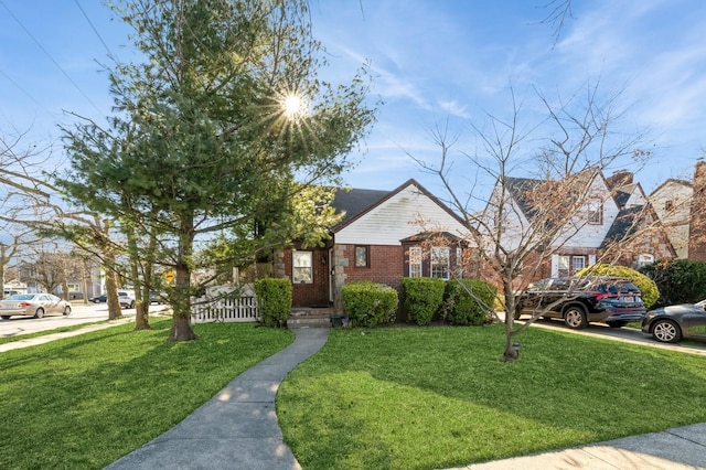 view of front of house with a front yard and brick siding