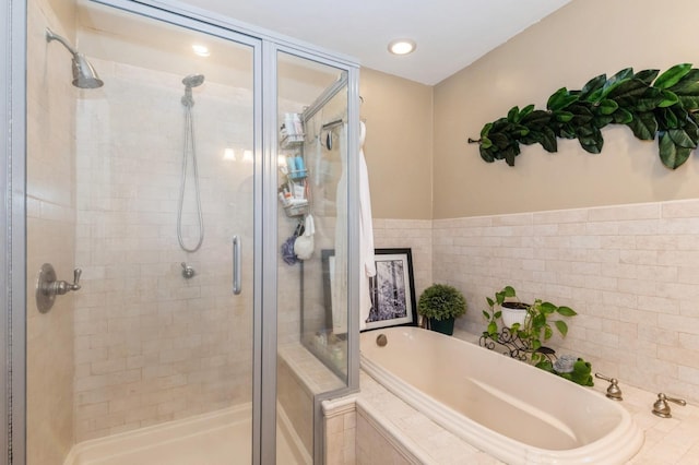 full bathroom featuring a bath and a shower stall