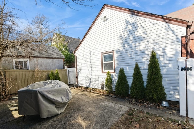 view of home's exterior with a patio and fence