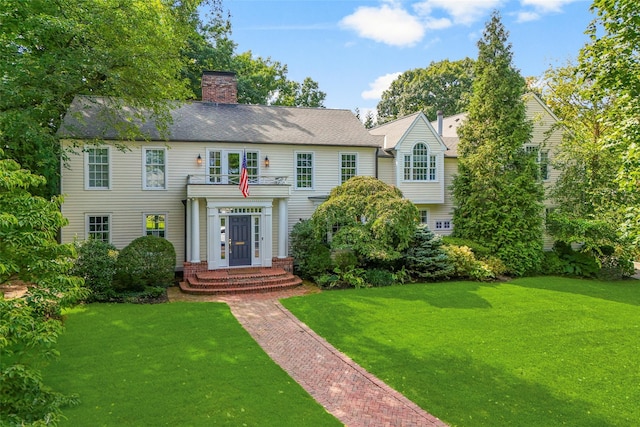 view of front of property featuring a front lawn and a chimney