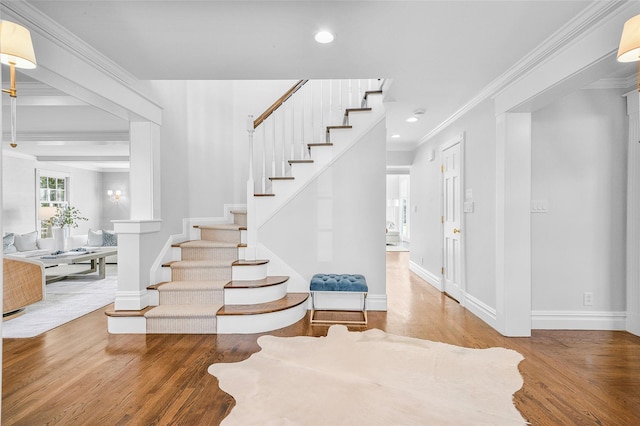 staircase with crown molding, recessed lighting, wood finished floors, and baseboards