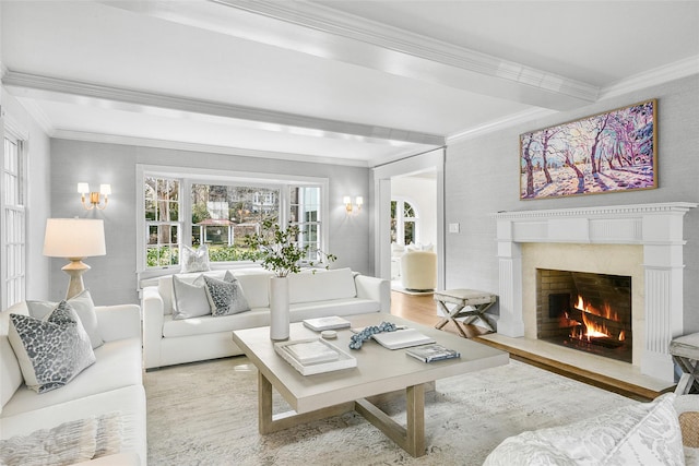 living room with a high end fireplace, crown molding, and wood finished floors