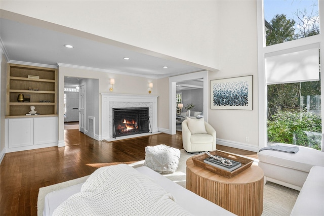 living room with baseboards, ornamental molding, recessed lighting, a fireplace, and wood finished floors