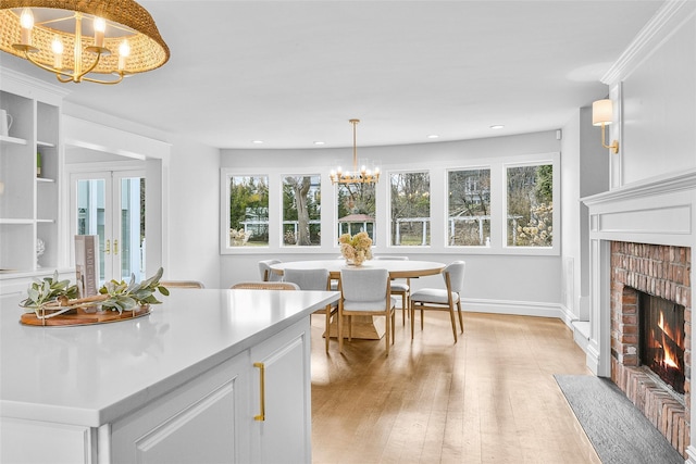 interior space featuring baseboards, a chandelier, recessed lighting, a fireplace, and light wood-style floors