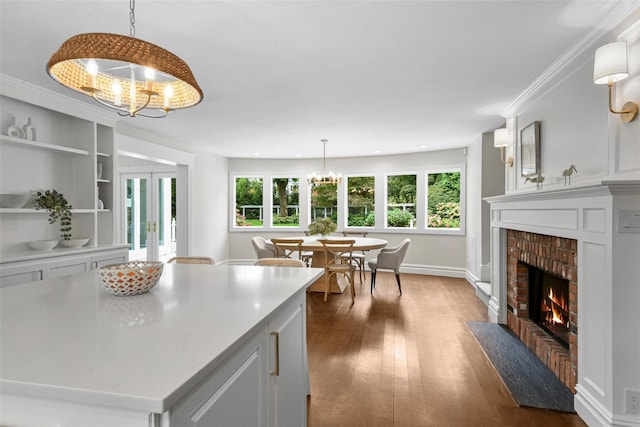 kitchen with plenty of natural light, french doors, a fireplace, a chandelier, and dark wood-style flooring