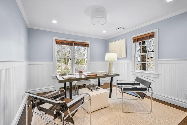 office area featuring wood finished floors, a healthy amount of sunlight, and wainscoting