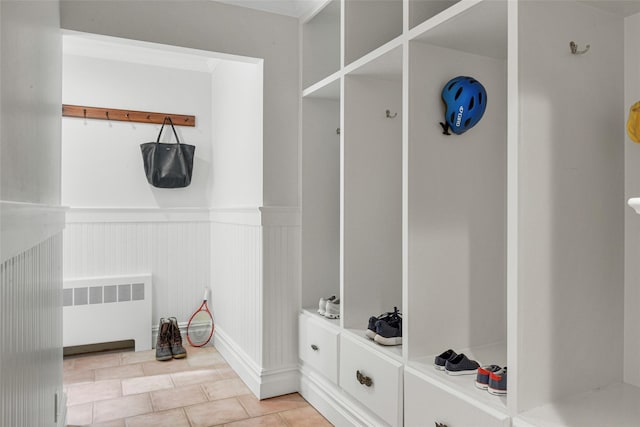 mudroom featuring a wainscoted wall, light tile patterned flooring, and radiator heating unit