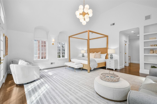 bedroom with wood finished floors, visible vents, and high vaulted ceiling