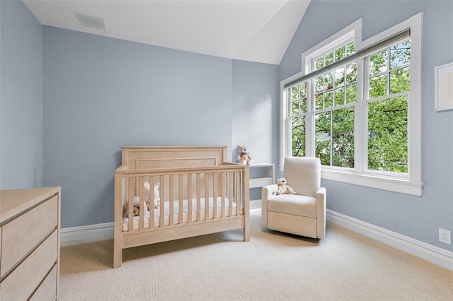 bedroom with lofted ceiling, a nursery area, light colored carpet, and baseboards