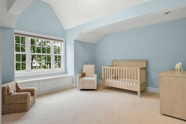 bedroom featuring carpet flooring, a crib, baseboards, and vaulted ceiling