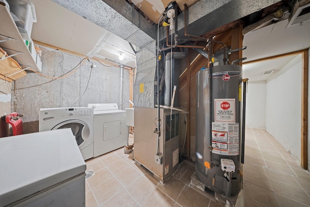 interior space featuring washing machine and dryer, water heater, visible vents, and heating unit