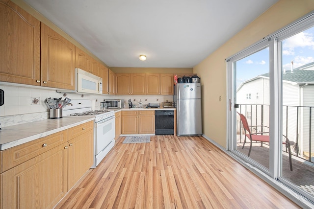 kitchen with stainless steel appliances, light wood-type flooring, light countertops, and light brown cabinetry